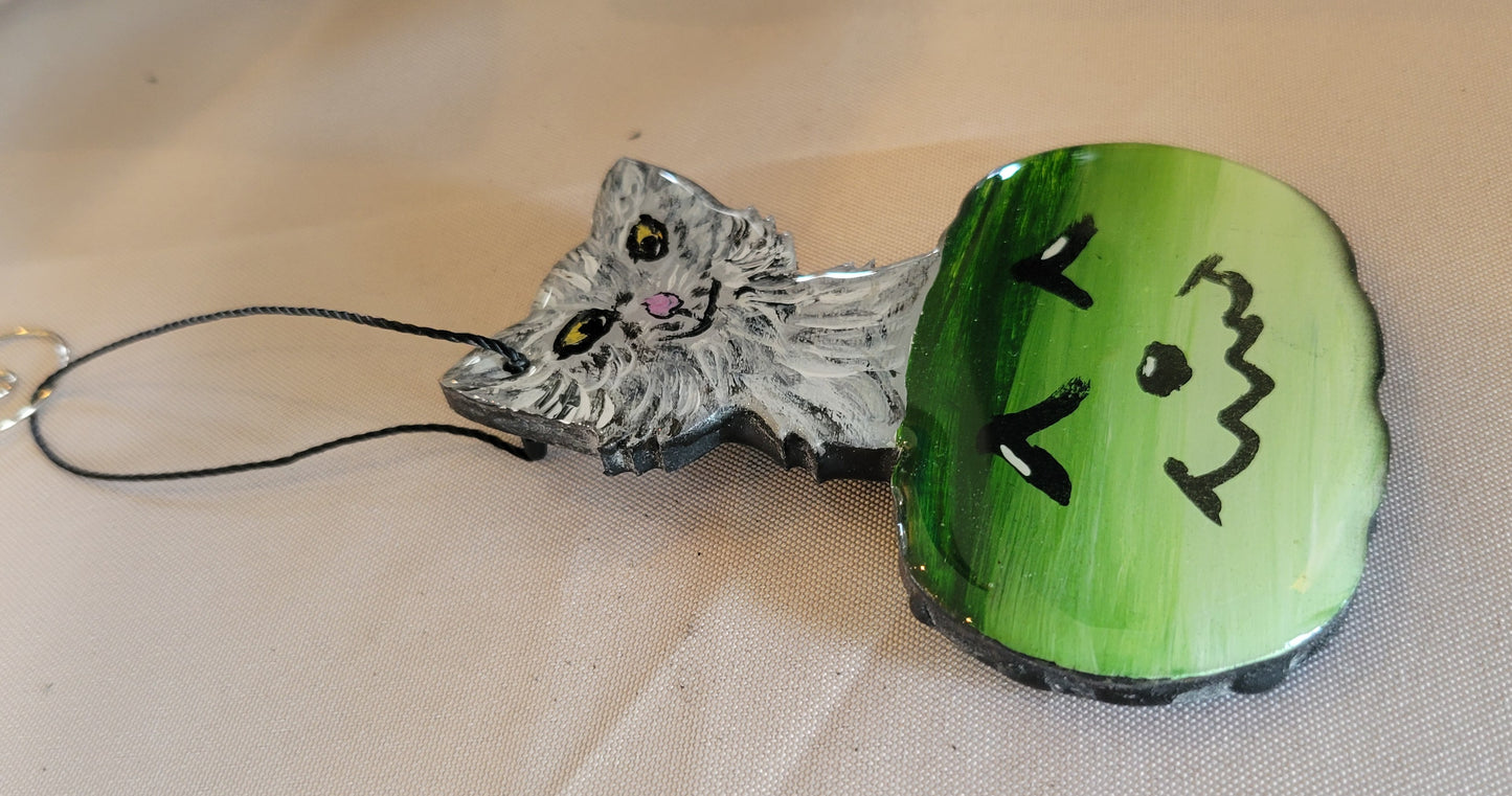 Playful Purrfection: Smirking Cat in a Jolly Green Pumpkin Ornament
