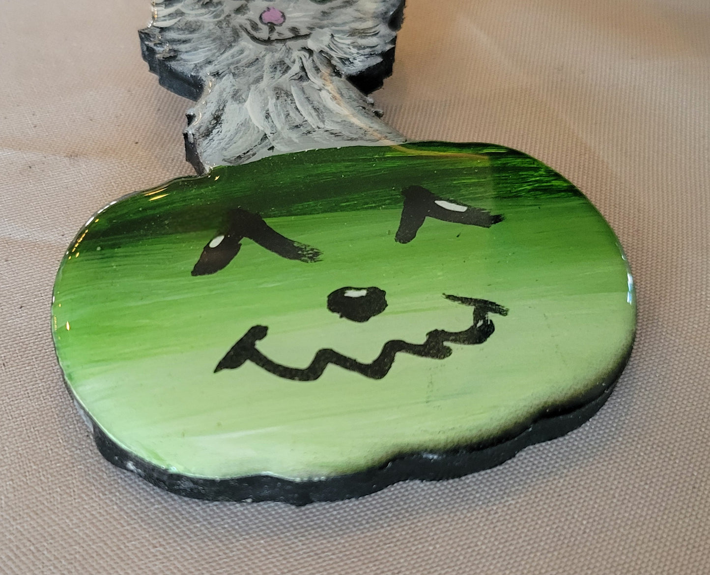 Playful Purrfection: Smirking Cat in a Jolly Green Pumpkin Ornament