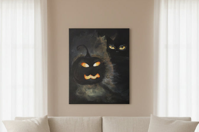 Beige sofa in a living room with a black cat painting on the wall.