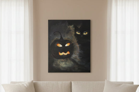 Beige sofa in a living room with a black cat painting on the wall.