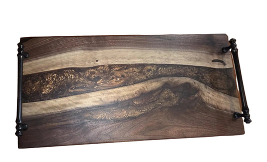 Wooden cutting board with black metal handles on a wooden surface