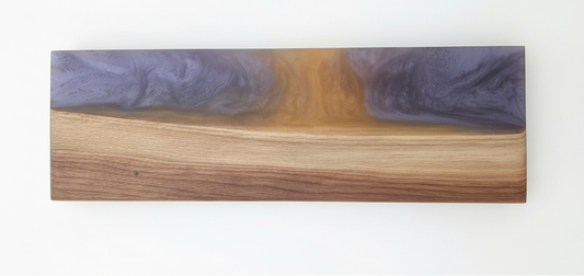 Wooden slab with purple resin inlay on a white background