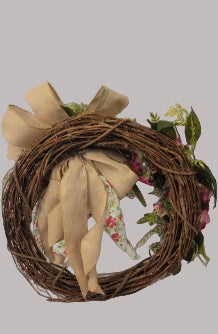 Wreath with burlap bow and floral accents on a plain background