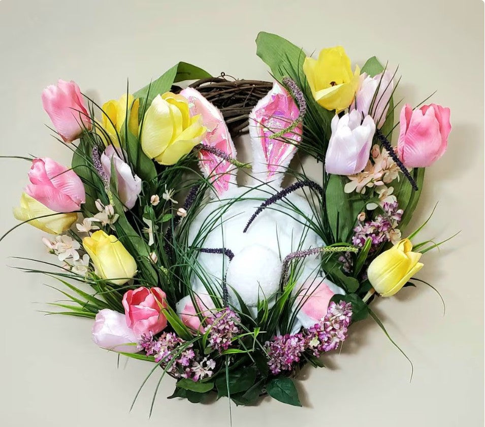 Decorative wreath with flowers and a white rabbit on a light background